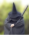 Un magicien en position mystérieuse avec une chapeau et une cape en laine noire