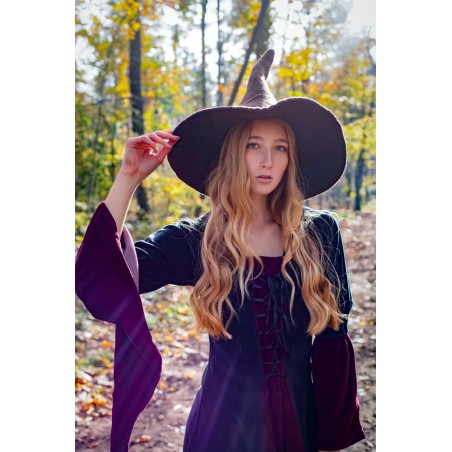 Jeune sorcière dans la forêt, robe violette et chapeau marron