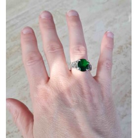 Au doigt la grosse pierre verte de cet anneau semble capturer la lumière
