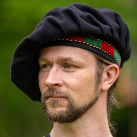 Le béret de ménestrel avec la bordure en velours rouge et verte