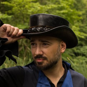 Homme portant un chapeau haut de forme en cuir noir vu de face